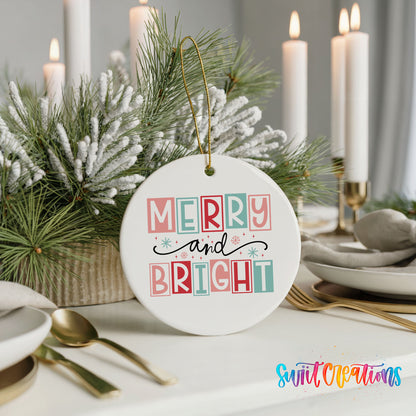 Round ceramic Christmas ornament featuring pastel block-letter Merry and Bright holiday typography, styled with elegant holiday table decor