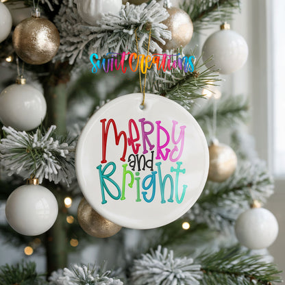 Round ceramic Christmas ornament featuring colorful hand-lettered Merry and Bright holiday typography, hanging on a frosted holiday tree