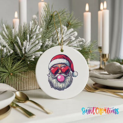 Round ceramic Christmas ornament featuring retro Santa wearing sunglasses and blowing pink bubblegum, styled with elegant holiday table decor