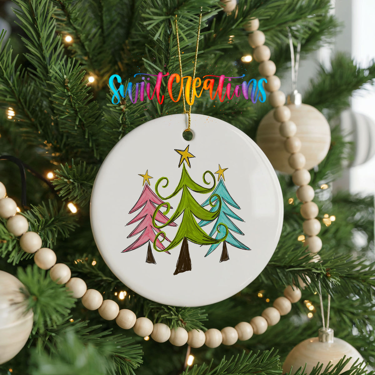 Round ceramic Christmas ornament featuring three colorful whimsical Christmas trees, hanging on a decorated Christmas tree