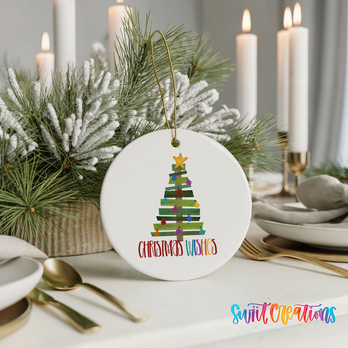 Round ceramic Christmas ornament featuring colorful pallet-style Christmas tree with Christmas Wishes lettering, styled with elegant holiday table decor