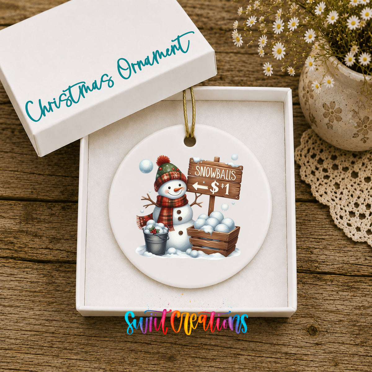 Round ceramic Christmas ornament featuring cheerful snowman selling snowballs for five cents, displayed in the included gift box