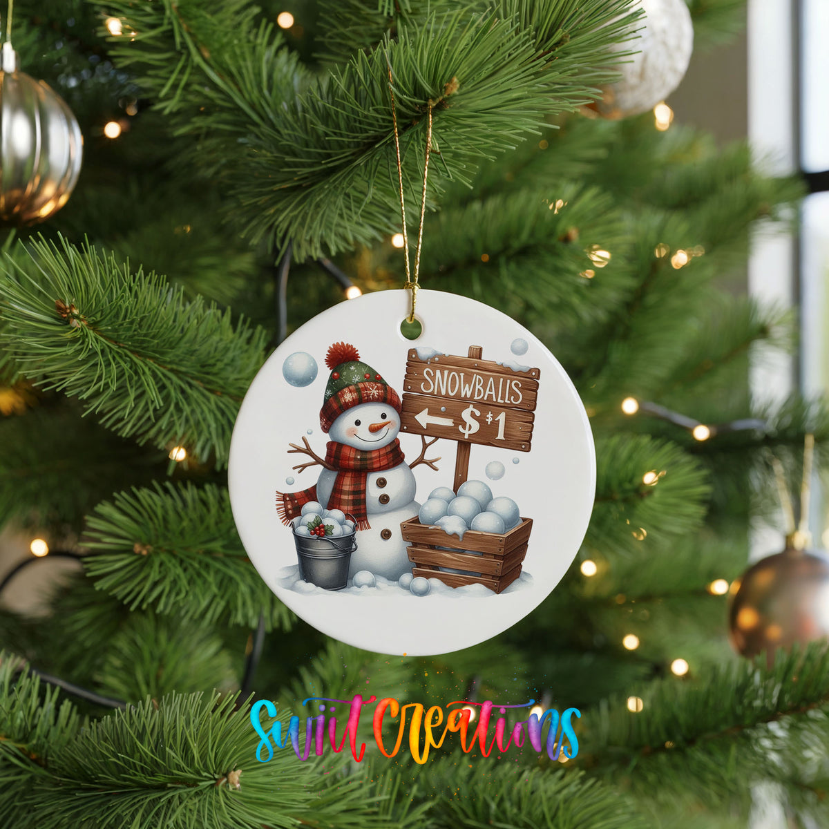 Round ceramic Christmas ornament featuring cheerful snowman selling snowballs for five cents, hanging on a green Christmas tree