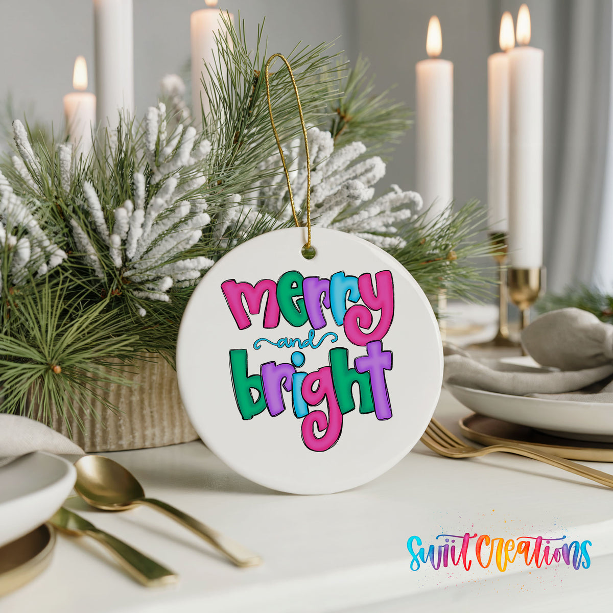 Round ceramic Christmas ornament featuring bright groovy Merry and Bright lettering in pink teal and purple, styled with elegant holiday table decor
