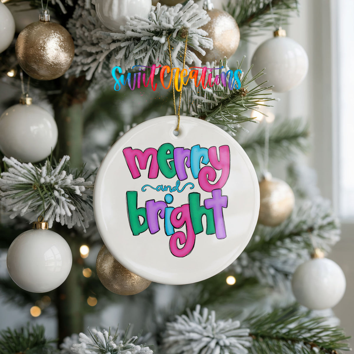 Round ceramic Christmas ornament featuring bright groovy Merry and Bright lettering in pink teal and purple, hanging on a frosted holiday tree