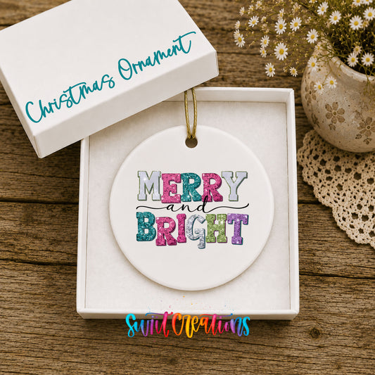 Round ceramic Christmas ornament featuring distressed patchwork Merry and Bright holiday typography, displayed in the included gift box