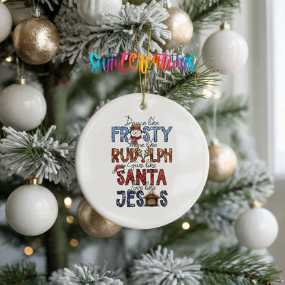 Round ceramic Christmas ornament featuring Dance like Frosty ride like Rudolph give like Santa love like Jesus message, hanging on a frosted holiday tree