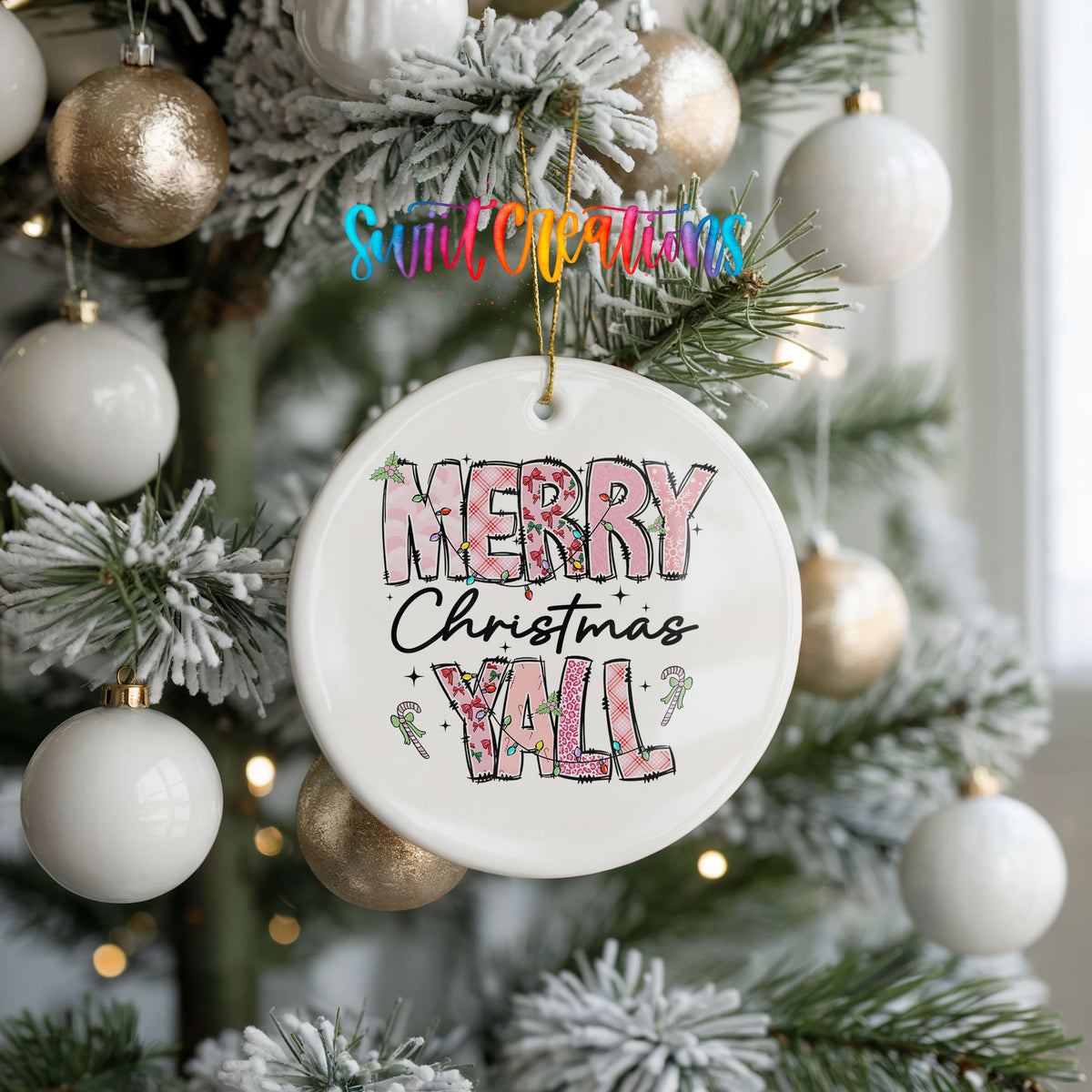 Round ceramic Christmas ornament featuring patterned Merry Christmas Y’all lettering with pink and green accents, hanging on a frosted holiday tree
