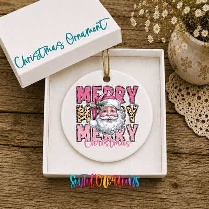 Round ceramic Christmas ornament featuring stacked Merry Merry Merry Christmas lettering with Santa and leopard print accents, displayed in the included gift box