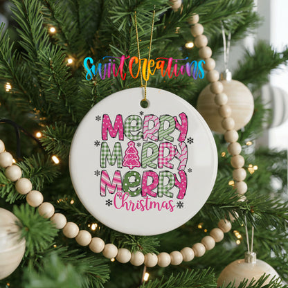 Round ceramic Christmas ornament featuring stacked patterned Merry Merry Merry Christmas lettering in pink and green, hanging on a decorated Christmas tree