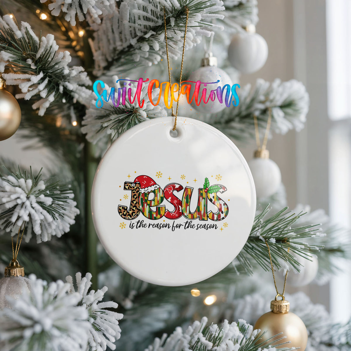Round ceramic Christmas ornament featuring colorful Jesus Is the Reason for the Season typography, hanging on a frosted Christmas tree