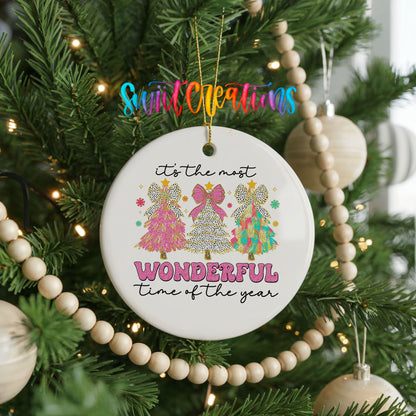 Round ceramic Christmas ornament featuring It’s the Most Wonderful Time of the Year lettering with colorful gifts and trees, hanging on a decorated Christmas tree