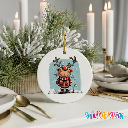 Round ceramic Christmas ornament featuring smiling reindeer in red plaid winter clothes against a snowy blue background, styled with elegant holiday table decor