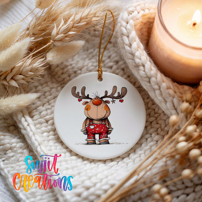 Reindeer in Red Plaid Sweater Christmas ornament styled beside a candle and cozy knit blanket