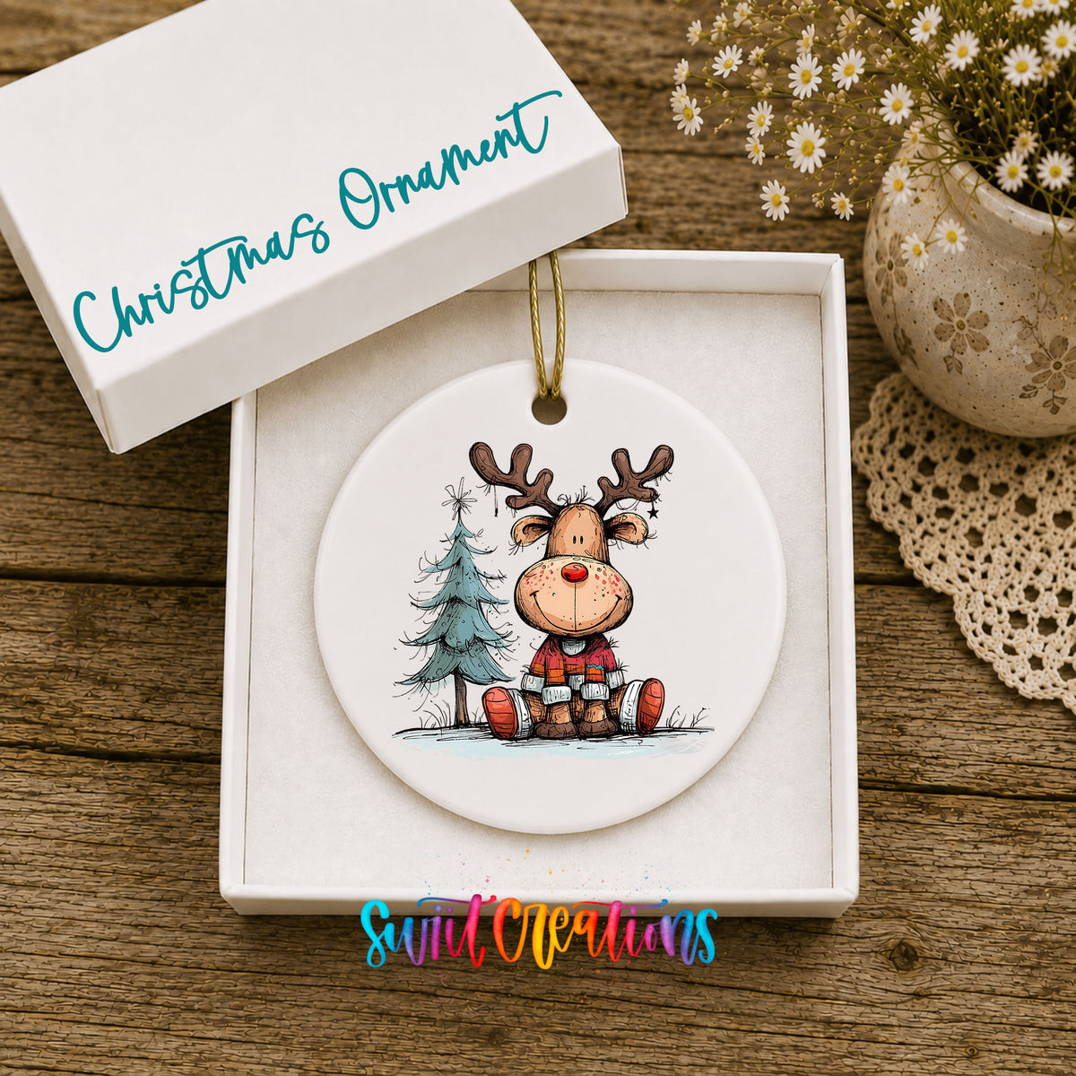 Sitting Reindeer with Pine Trees and Gift Christmas ornament displayed in an included gift box