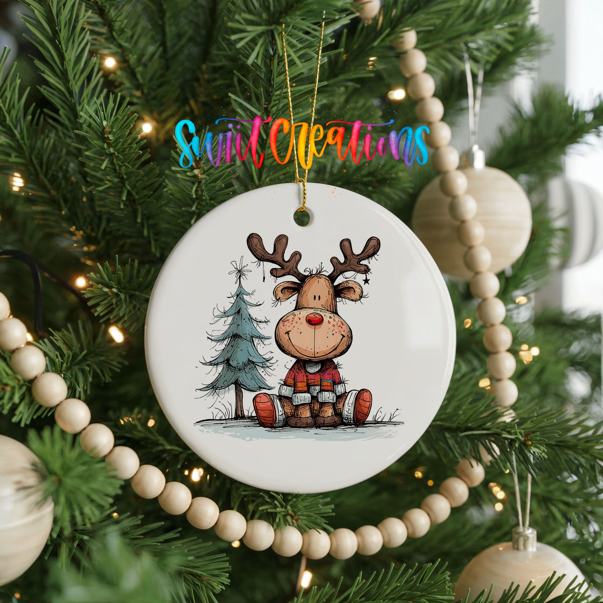 Sitting Reindeer with Pine Trees and Gift Christmas ornament hanging on a decorated Christmas tree