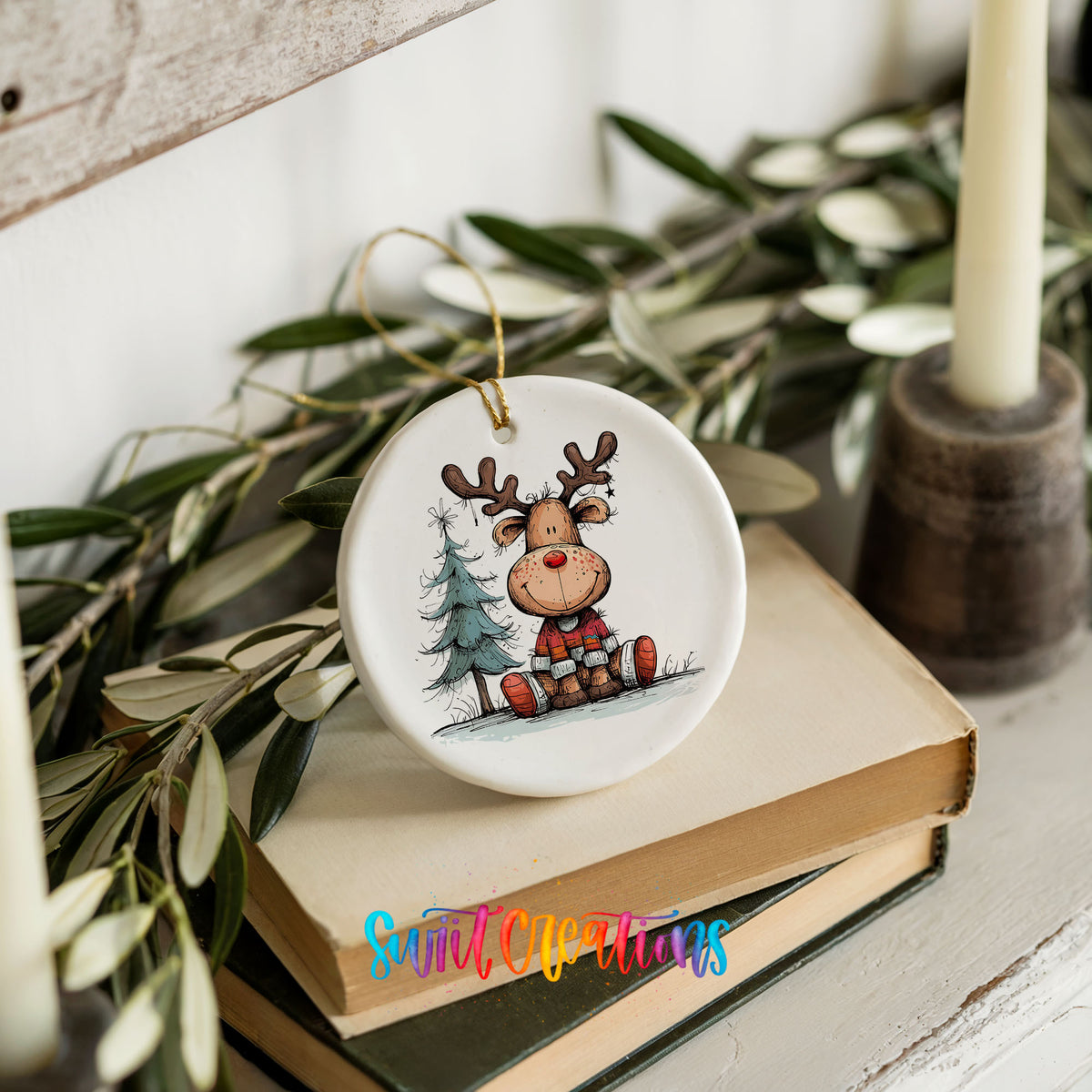 Sitting Reindeer with Pine Trees and Gift Christmas ornament styled on books with holiday greenery