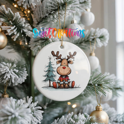 Sitting Reindeer with Pine Trees and Gift Christmas ornament hanging on a frosted Christmas tree