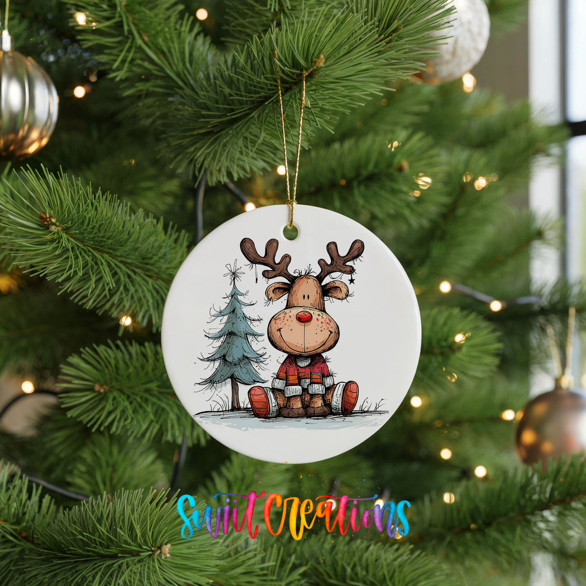 Sitting Reindeer with Pine Trees and Gift Christmas ornament hanging on a green Christmas tree