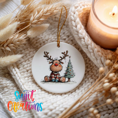 Sitting Reindeer Beside Christmas Tree Christmas ornament styled beside a candle and cozy knit blanket