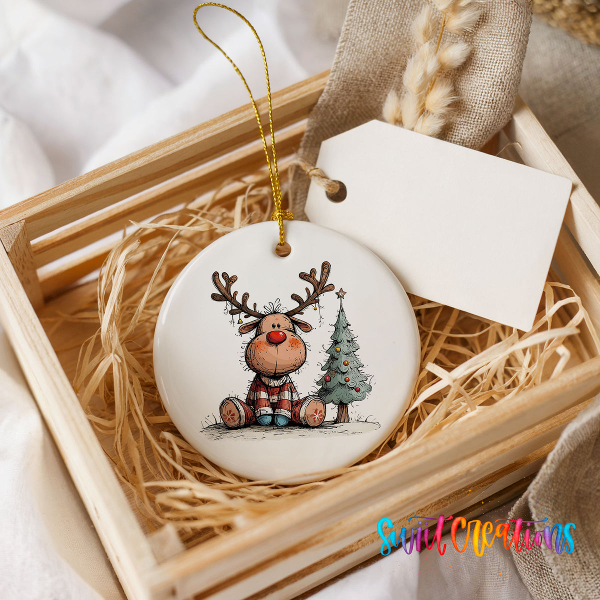 Sitting Reindeer Beside Christmas Tree Christmas ornament presented in a rustic wooden gift crate