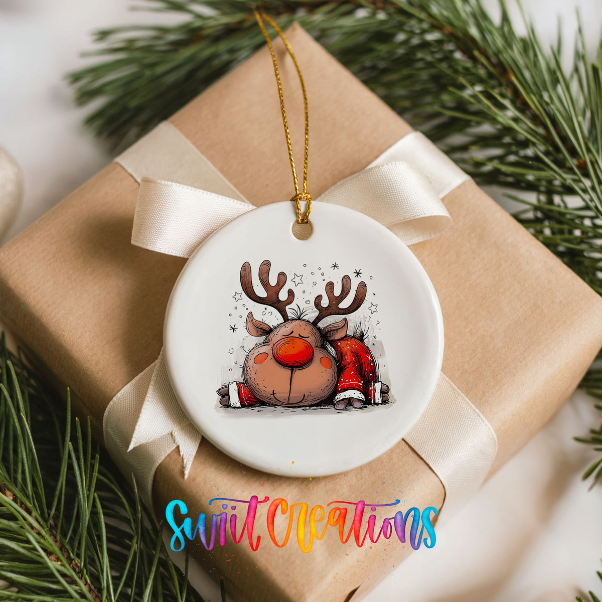 Sleeping Reindeer in Red Scarf Christmas ornament placed on a wrapped Christmas gift