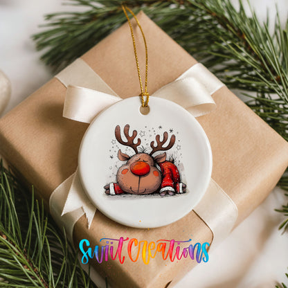 Sleeping Reindeer in Red Scarf Christmas ornament placed on a wrapped Christmas gift