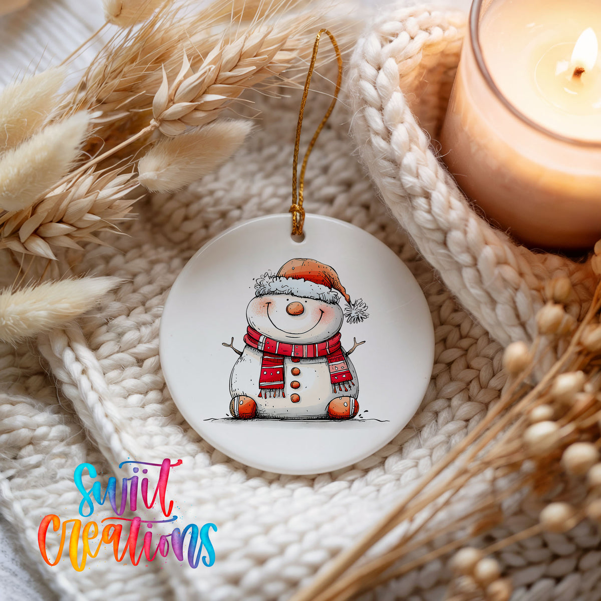 Cheerful Snowman in Santa Hat Christmas ornament styled beside a candle and cozy knit blanket
