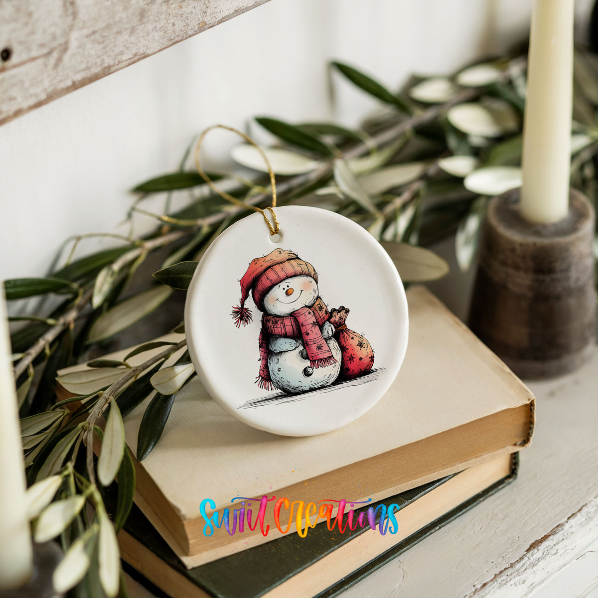 Snowman in Red Scarf with Gift Christmas ornament styled on books with holiday greenery
