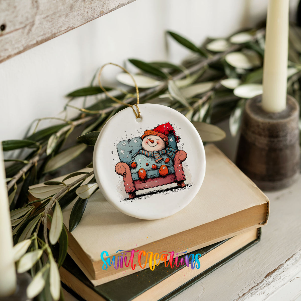 Santa Resting in a Holiday Armchair Christmas ornament styled on books with holiday greenery