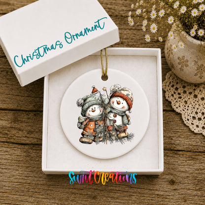 Snowman Pair in Orange and Gray Hats ceramic Christmas ornament displayed in gift box