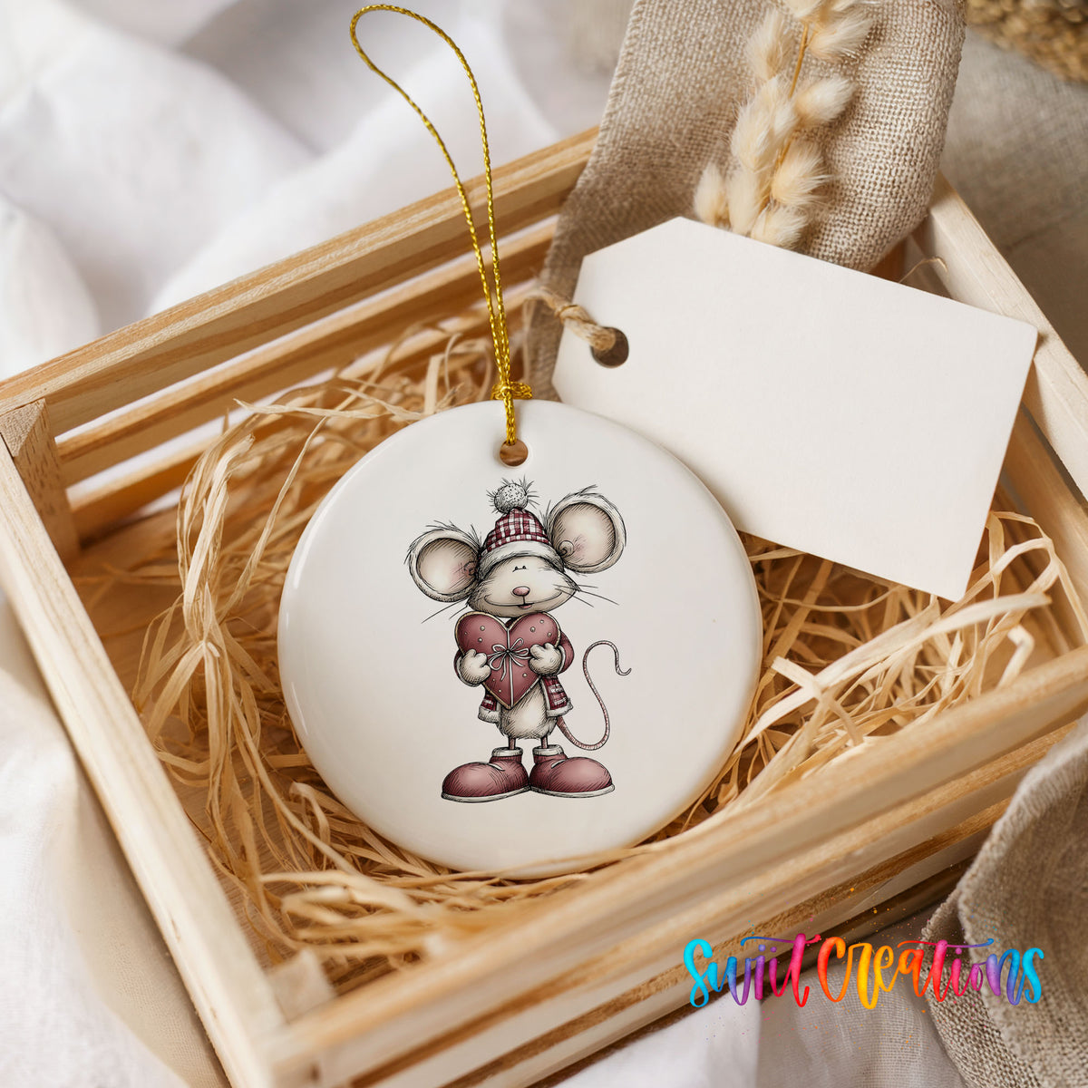 pink mouse holding a heart ceramic Christmas ornament displayed in a wooden gift crate
