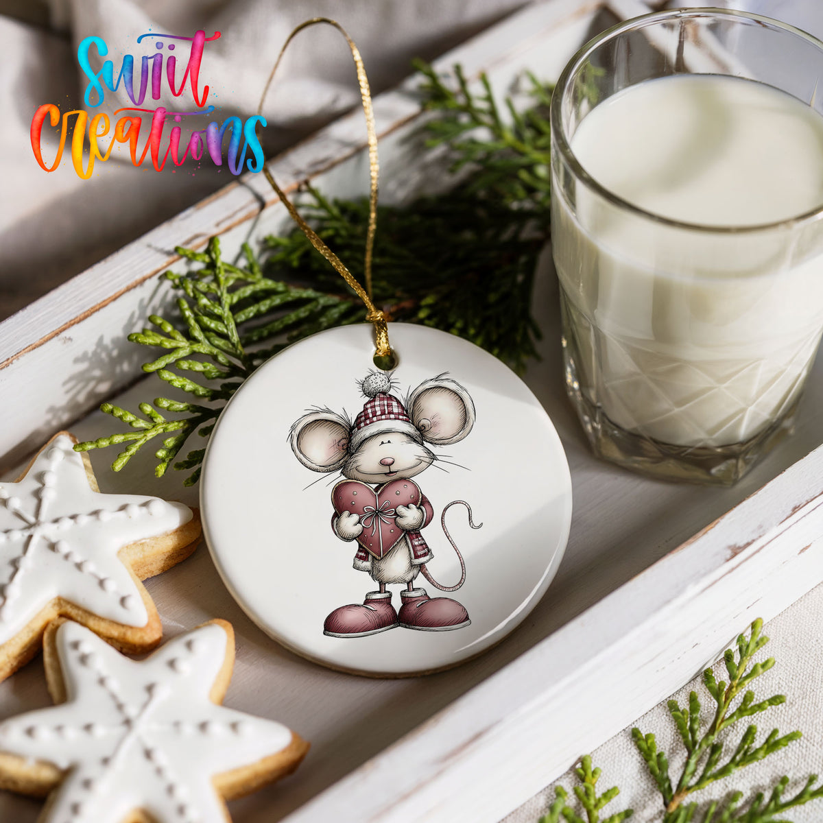 pink mouse holding a heart ceramic Christmas ornament styled with holiday cookies and a candle