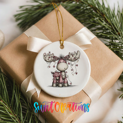pink reindeer with hanging ornaments ceramic Christmas ornament displayed on a wrapped Christmas gift