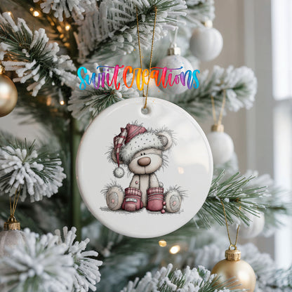 teddy bear in a Santa hat with Christmas gifts ceramic Christmas ornament hanging on a frosted Christmas tree