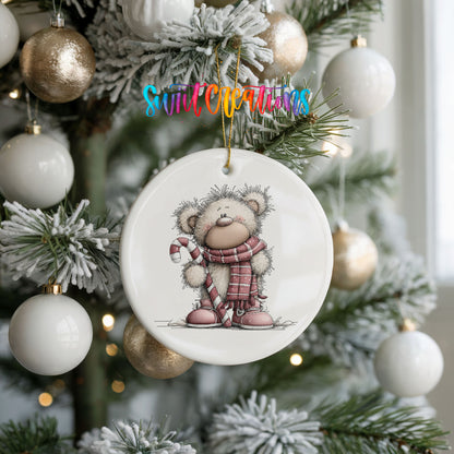 teddy bear holding a candy cane in winter clothes ceramic Christmas ornament hanging on a frosted tree with ornaments