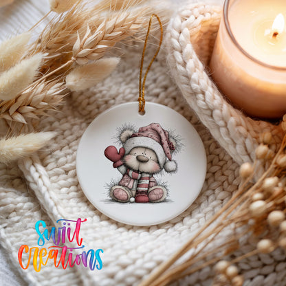 teddy bear holding a pink heart in a Santa hat ceramic Christmas ornament styled on a cozy knit blanket