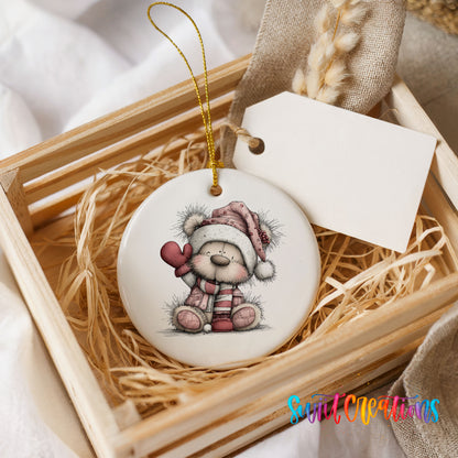 teddy bear holding a pink heart in a Santa hat ceramic Christmas ornament displayed in a wooden gift crate