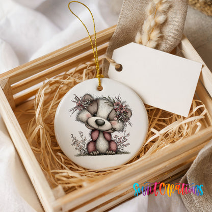 raccoon with winter flowers and greenery ceramic Christmas ornament displayed in a wooden gift crate