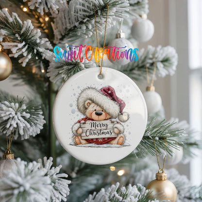 teddy bear holding a Merry Christmas sign ceramic Christmas ornament hanging on a frosted Christmas tree