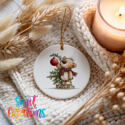 teddy bear holding a red ornament beside a Christmas tree ceramic Christmas ornament styled on a cozy knit blanket