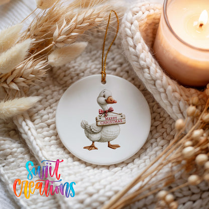 Christmas goose holding a Merry Christmas sign ceramic Christmas ornament styled on a cozy knit blanket