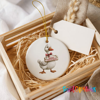 Christmas goose holding a Merry Christmas sign ceramic Christmas ornament displayed in a wooden gift crate