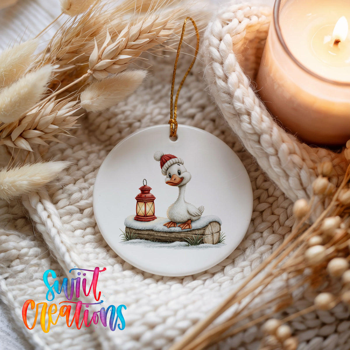 Christmas goose standing beside a red lantern ceramic Christmas ornament styled on a cozy knit blanket