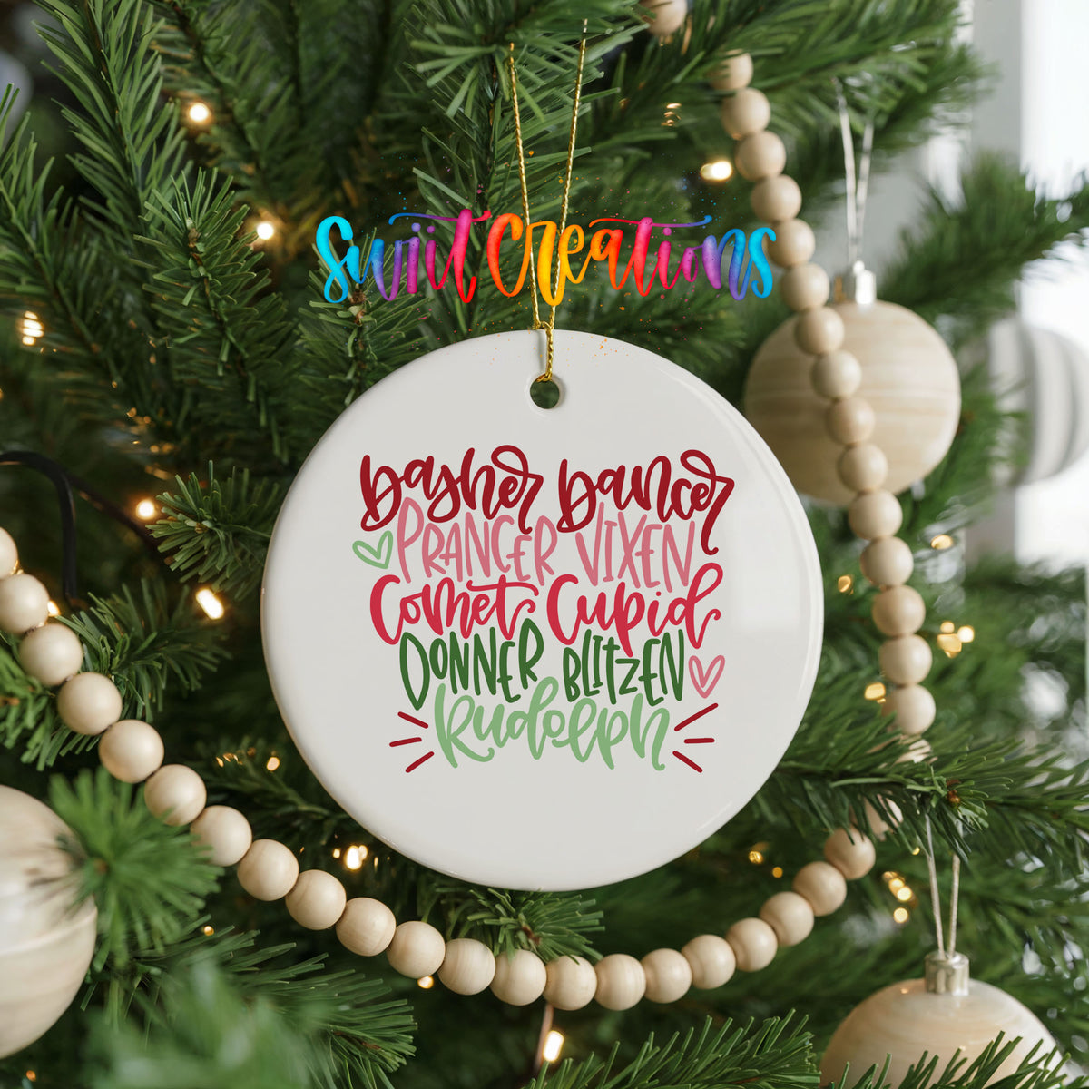 Colorful reindeer names typography ceramic Christmas ornament hanging on a decorated Christmas tree