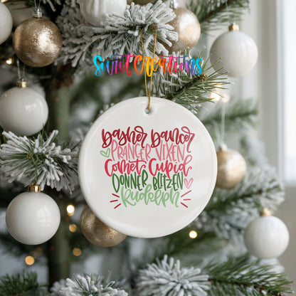 Colorful reindeer names typography ceramic Christmas ornament hanging on a frosted holiday tree