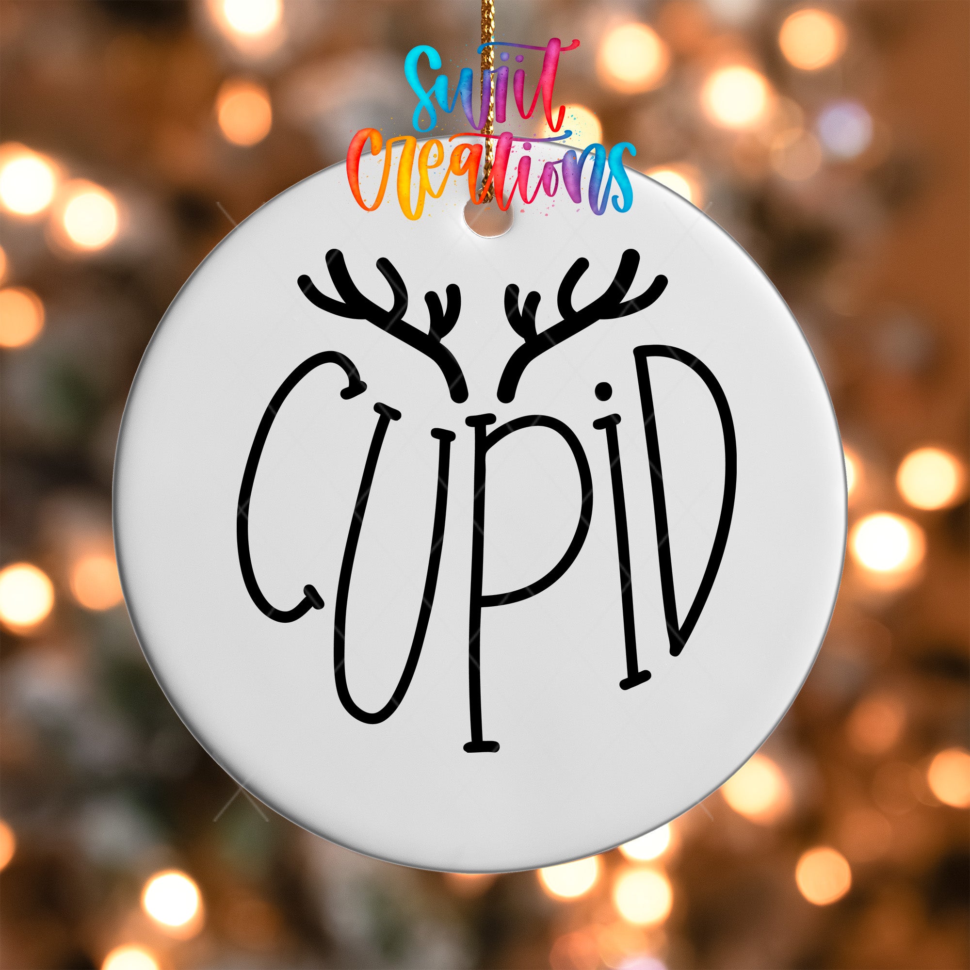 A white ornament with the word "CUPID" written on it, hanging against a background of colorful lights.