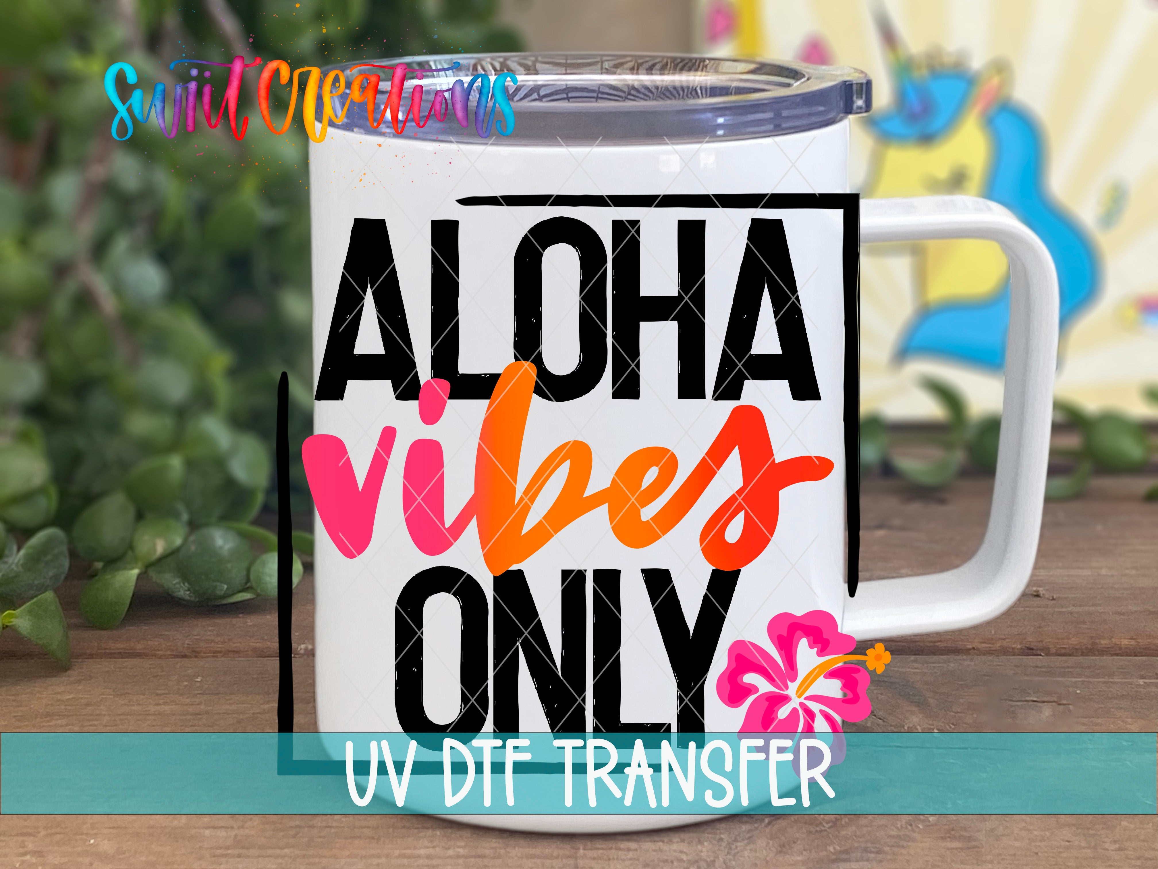 A white mug with the text "ALOHA VIBES ONLY" printed on it, along with a pink flower and a unicorn graphic.