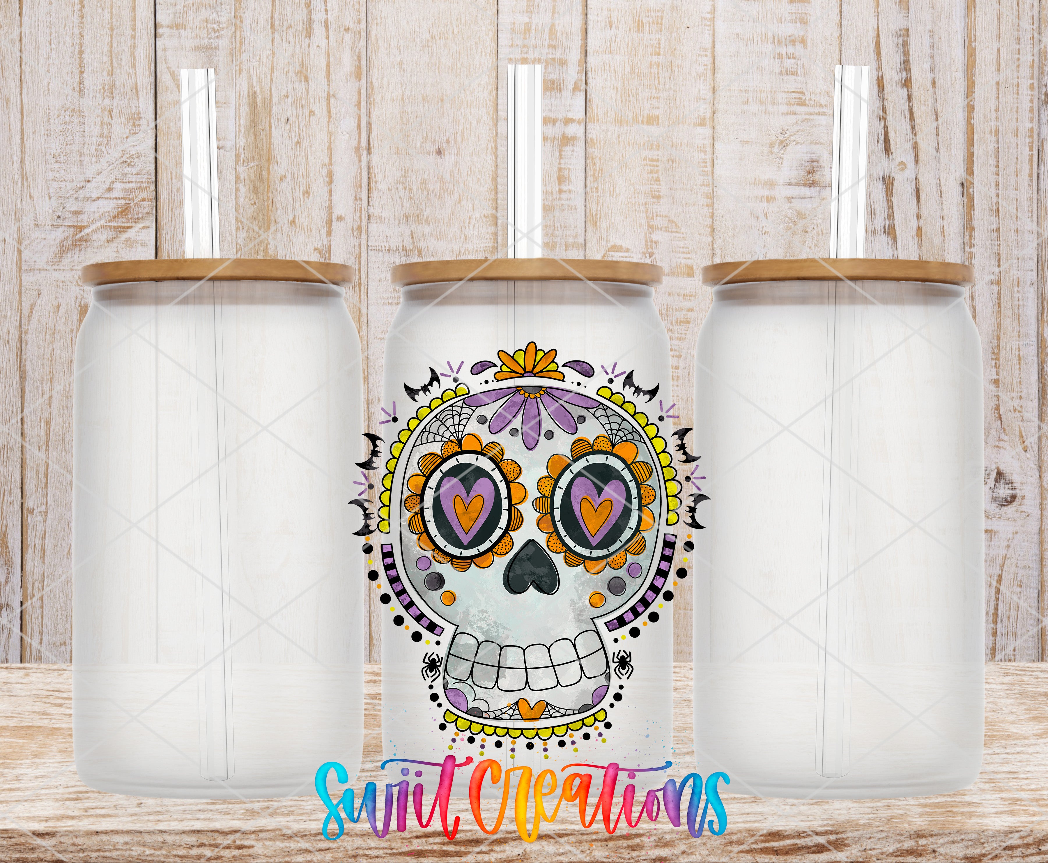 three glass tumblers with a colorful design resembling a skull, which is a popular motif associated with the Day of the Dead celebration.