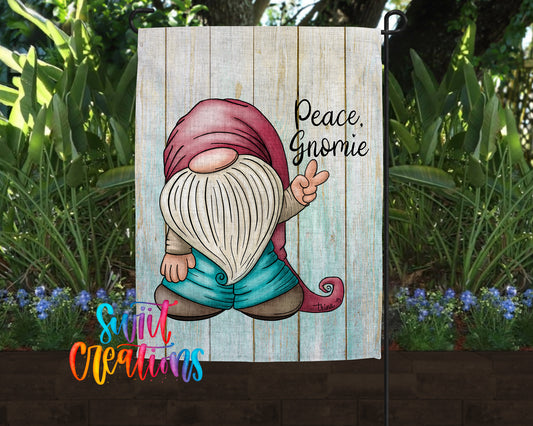 A garden gnome with a peace sign is depicted on a wooden sign, surrounded by greenery and flowers.